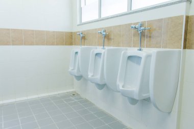 Bir sıra pisuar erkekler umumi tuvalet, erkekler tuvaletinde kapalı beyaz pisuarlar, erkekler için beyaz seramik pisuar tasarımı..