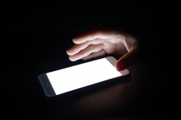 white light from the smartphone reflect your hand at night in the dark.blank screen for text and design