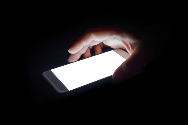 white light from the smartphone reflect your hand at night in the dark.blank screen for text and design