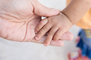 Yeni doğan bebeğin elini tutarak annesi el