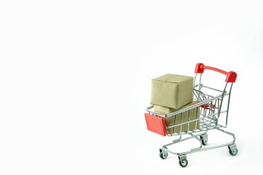 Alışveriş konsepti: beyaz arka planda kırmızı alışveriş arabasında karton veya karton kutular. Çevrimiçi alışveriş tüketicileri evden ve teslimat servisinden alışveriş yapabilirler. kopyalama alanı ile