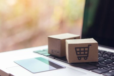 İnternetten alışveriş, kağıt kutular ya da klavyede alışveriş arabası logosu ve kredi kartı olan bir paket. İnternet üzerinden alışveriş hizmeti sunuyor..