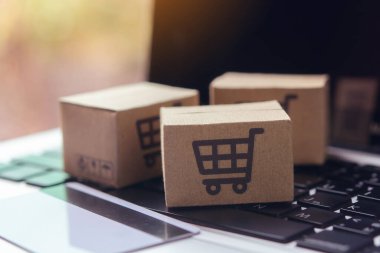 İnternetten alışveriş, kağıt kutular ya da klavyede alışveriş arabası logosu ve kredi kartı olan bir paket. İnternet üzerinden alışveriş hizmeti sunuyor..