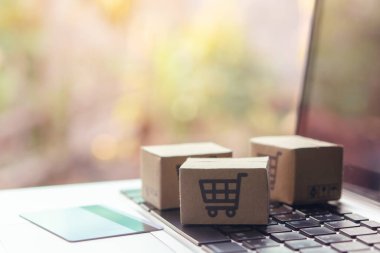 İnternetten alışveriş, kağıt kutular ya da klavyede alışveriş arabası logosu ve kredi kartı olan bir paket. İnternet üzerinden alışveriş hizmeti sunuyor..