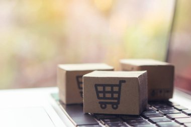 İnternetten alışveriş, kağıt kutular ya da klavyede alışveriş arabası logosu olan bir paket. İnternet üzerinden alışveriş hizmeti sunuyor..