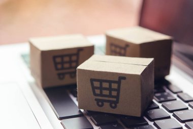 İnternetten alışveriş, kağıt kutular ya da klavyede alışveriş arabası logosu olan bir paket. İnternet üzerinden alışveriş hizmeti sunuyor..