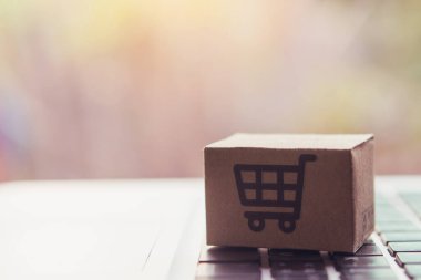 İnternetten alışveriş, kağıt kutular ya da klavyede alışveriş arabası logosu olan bir paket. İnternet üzerinden alışveriş hizmeti sunuyor..