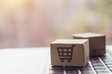 İnternetten alışveriş, kağıt kutular ya da klavyede alışveriş arabası logosu olan bir paket. İnternet üzerinden alışveriş hizmeti sunuyor..