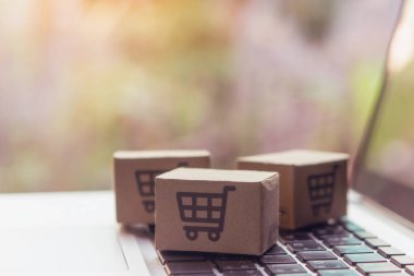 İnternetten alışveriş, kağıt kutular ya da klavyede alışveriş arabası logosu olan bir paket. İnternet üzerinden alışveriş hizmeti sunuyor..