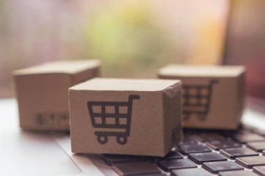 İnternetten alışveriş, kağıt kutular ya da klavyede alışveriş arabası logosu olan bir paket. İnternet üzerinden alışveriş hizmeti sunuyor..
