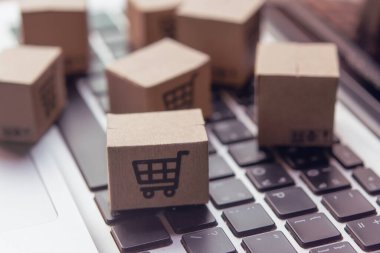 İnternetten alışveriş, kağıt kutular ya da klavyede alışveriş arabası logosu olan bir paket. İnternet üzerinden alışveriş hizmeti sunuyor..