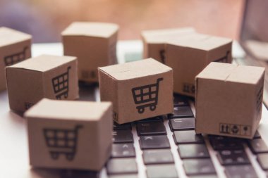 İnternetten alışveriş, kağıt kutular ya da klavyede alışveriş arabası logosu olan bir paket. İnternet üzerinden alışveriş hizmeti sunuyor..