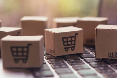 İnternetten alışveriş, kağıt kutular ya da klavyede alışveriş arabası logosu olan bir paket. İnternet üzerinden alışveriş hizmeti sunuyor..