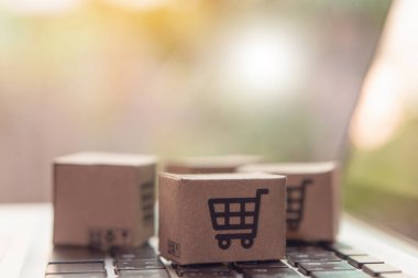 İnternetten alışveriş, kağıt kutular ya da klavyede alışveriş arabası logosu olan bir paket. İnternet üzerinden alışveriş hizmeti sunuyor..