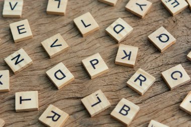 background of letterpress wood type printing blocks on wooden background, random letters of alphabet and punctuation stained by black ink