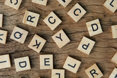 background of letterpress wood type printing blocks on wooden background, random letters of alphabet and punctuation stained by black ink