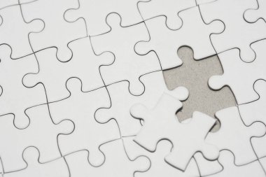 Beyaz yapboz desenli arka plan. Yapbozun son parçası yerleştiriliyor