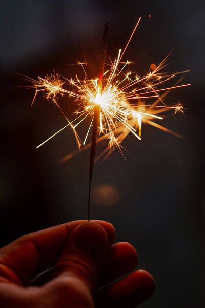 Женщина держит горящий бенгальский огонь, Рождество и Новый год игристый праздничный фон
