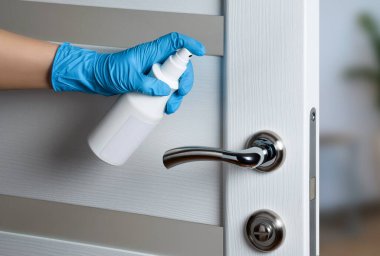 COVID-19 salgını sırasında viral enfeksiyonu önlemek için kapı kolu dezenfeksiyonu. Beyaz kapı. Kapı tokmağı.