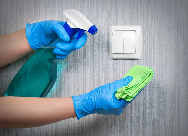 Dezynfekcja przełącznika światła, aby zapobiec zakażeniu koronawirusem. Sprzątanie domu podczas pandemii.Czyszczenie przełącznika światła. — Zdjęcie stockowe