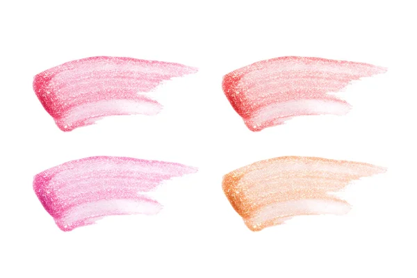 Différentes gloses de lèvres isolées sur du blanc. Échantillon de brillant à lèvres taché . — Photo