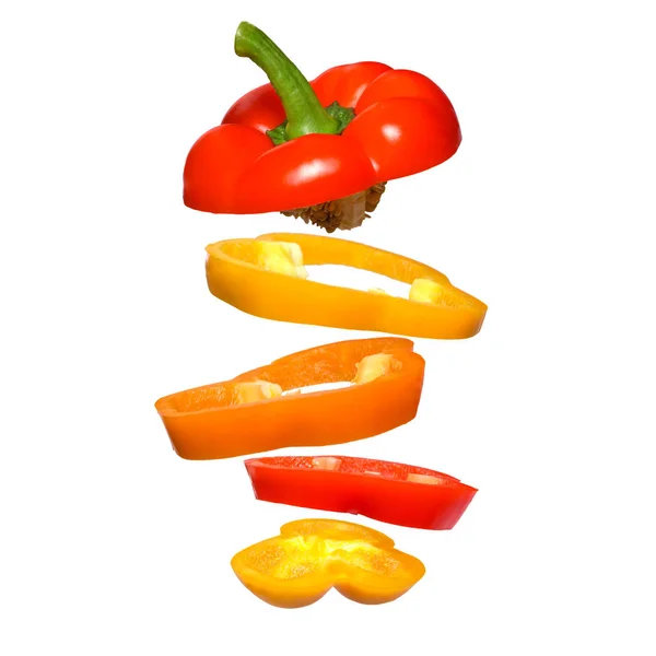 Flying red, orange and yellow paprika. Sliced floating pepper isolated. — Stock Photo, Image