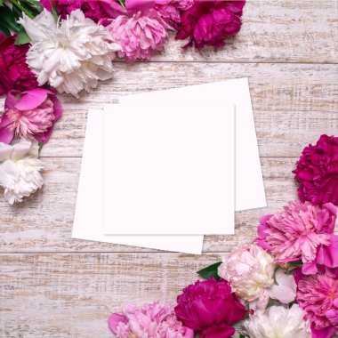 Metin için boş alan gazeteyle ahşap bir zemin üzerine peonies kenarlığını.