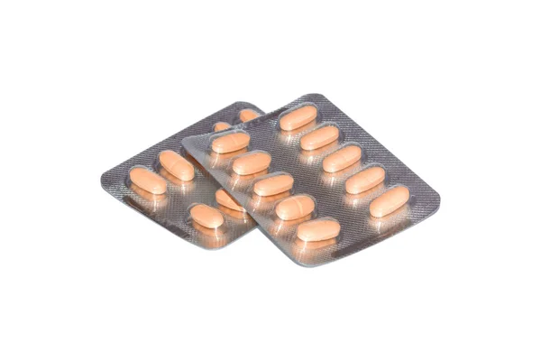 Gula tabletter förpackade i blister isolerad på vit bakgrund — Stockfoto