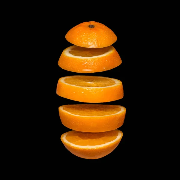 Креативная концепция с летающим апельсином. Нарезанный апельсин изолирован на черном фоне . — стоковое фото