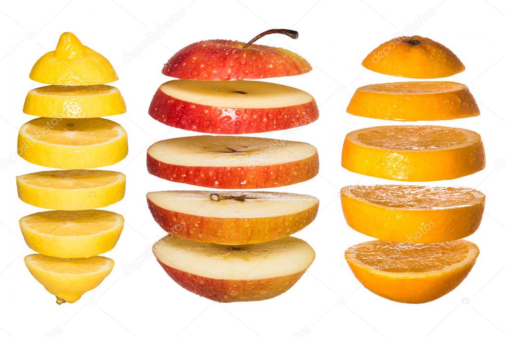 Creative concept with Flying fruits. Sliced orange, lemon, apple isolated on white.
