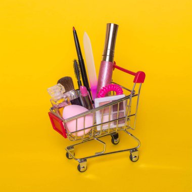 Sarı bir arka plan üzerinde makyaj ile arabası alışveriş ile yaratıcı kavramı.