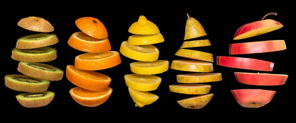 Creative concept with food. Set of sliced fruits isolated on black background. — Stock Photo, Image