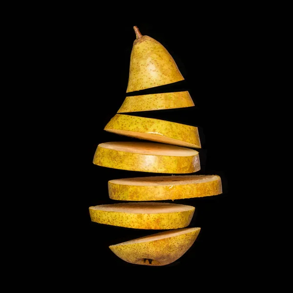 Creative concept with flying pear. Sliced pear isolated on black background — Stock Photo, Image