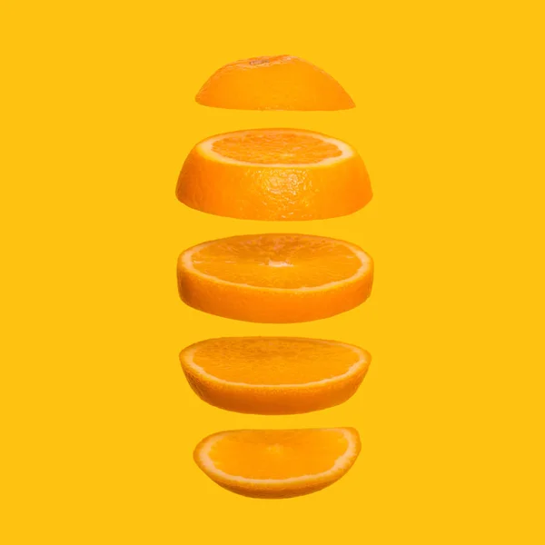 Concepto creativo con naranja voladora. Naranja en rodajas sobre fondo amarillo —  Fotos de Stock