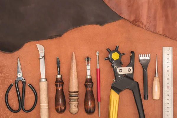 Tools for leather crafting and pieces of brown leather. Manufacture of leather — Stock Photo, Image