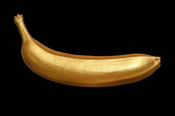 Gyllene banan på en svart bakgrund. Kreativa koncept med frukt. — Stockfoto