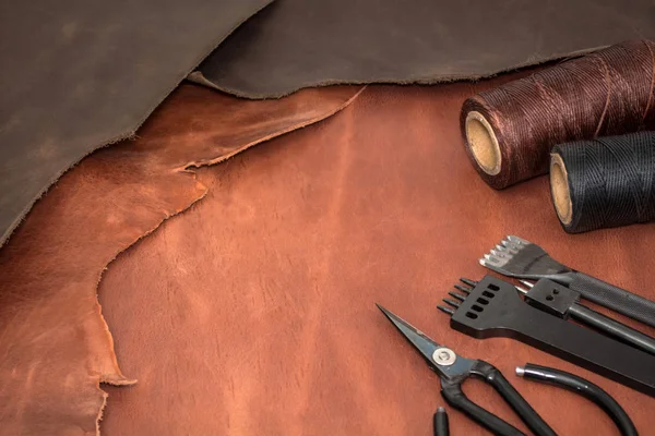 Ferramentas para artesanato de couro e pedaços de couro marrom. Fabricação de couro — Fotografia de Stock