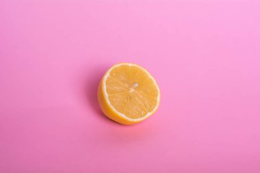 Pembe arka planda yarım limon.