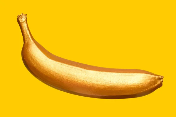 Gyllene bananen på gul bakgrund. Kreativa koncept med frukt. — Stockfoto