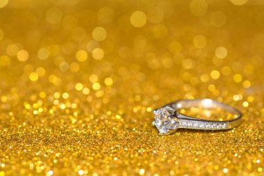Altın parlak zemin üzerine Pırlantalı yüzük. Glitter nişan yüzüğü