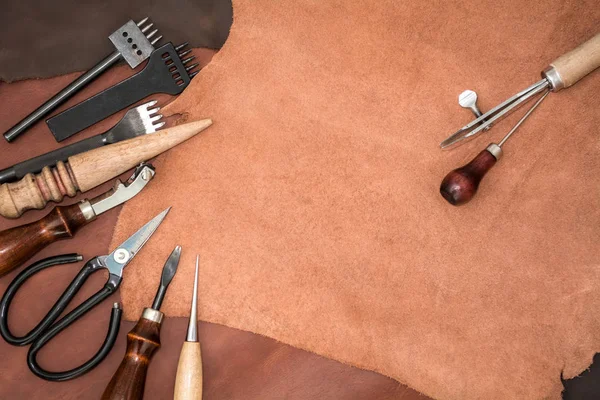 Piezas de cuero y herramientas de trabajo. Espacio de trabajo del artesano — Foto de Stock