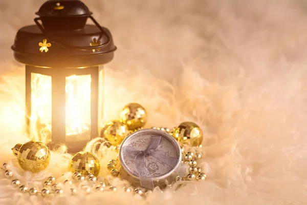 Újévi játékok fehér bundán. Lámpás, arany gyöngyök, ajándékdoboz és diszkógömbök. Karácsonyi kompozíció. — Stock Fotó