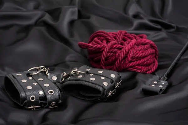 Deri kelepçe, Shibari ipi ve siyah arka plan yığını.