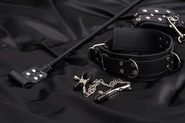 Leather Handcuffs Nipple Clamps Chain Collar Stack Black Silk Background — Stockfoto