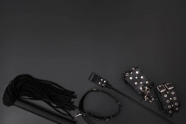 革の手錠 黒い鞭 襟と黒の背景にスタック 大人の性的ゲームのためのアクセサリー Bdsm衣装 — ストック写真