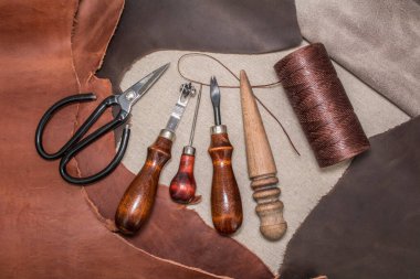 Deri işçiliği ve kahverengi deri parçaları için aletler. Deri ürünleri üretimi. Yukarıdan görüntüle