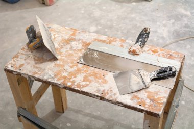 Tadilat için gerekli aletler. Keski, mala, macun bıçağı. Odadaki onarım işlemi..