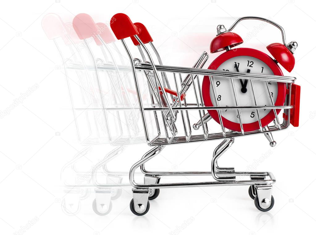 Shopping cart with alarm clock in it and moving blur behind. Concept of last minute shopping.