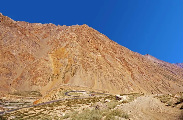 Een vrachtwagen op een kronkelende weg in de hooggelegen berg woestijn in de Himalaya — Stockfoto