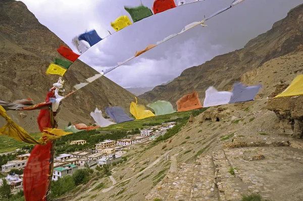 Anciennes grottes bouddhistes et drapeaux de prière dans le désert de montagne de haute altitude de l'Himalaya — Photo